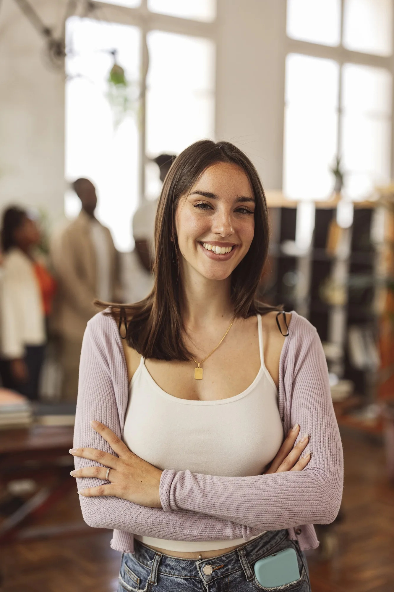 young caucasian business woman, in office with colleagues behind, happy smiling,